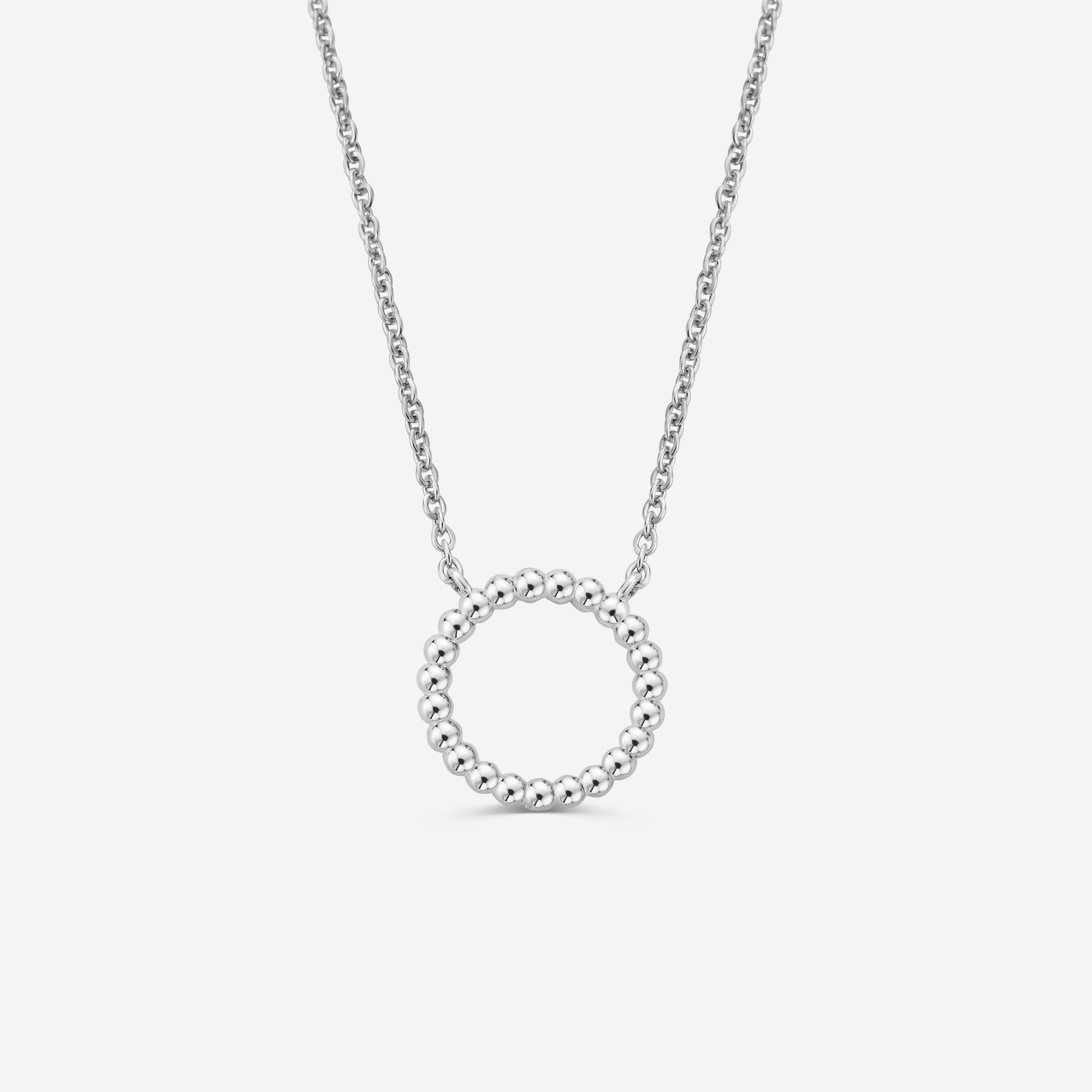 Silver necklace with a circular beaded pendant on a off white background