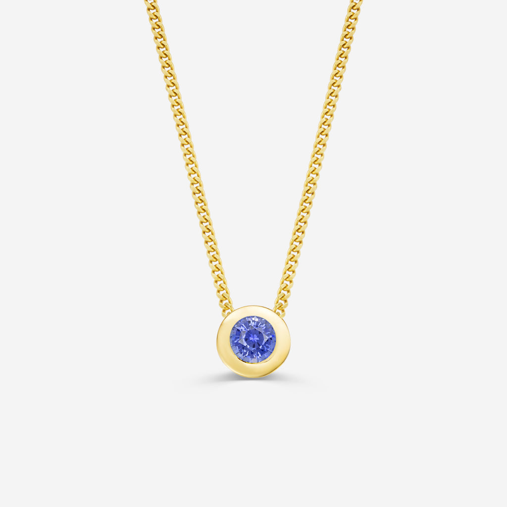 9ct yellow gold necklace with a round sapphire pendant on an off white background