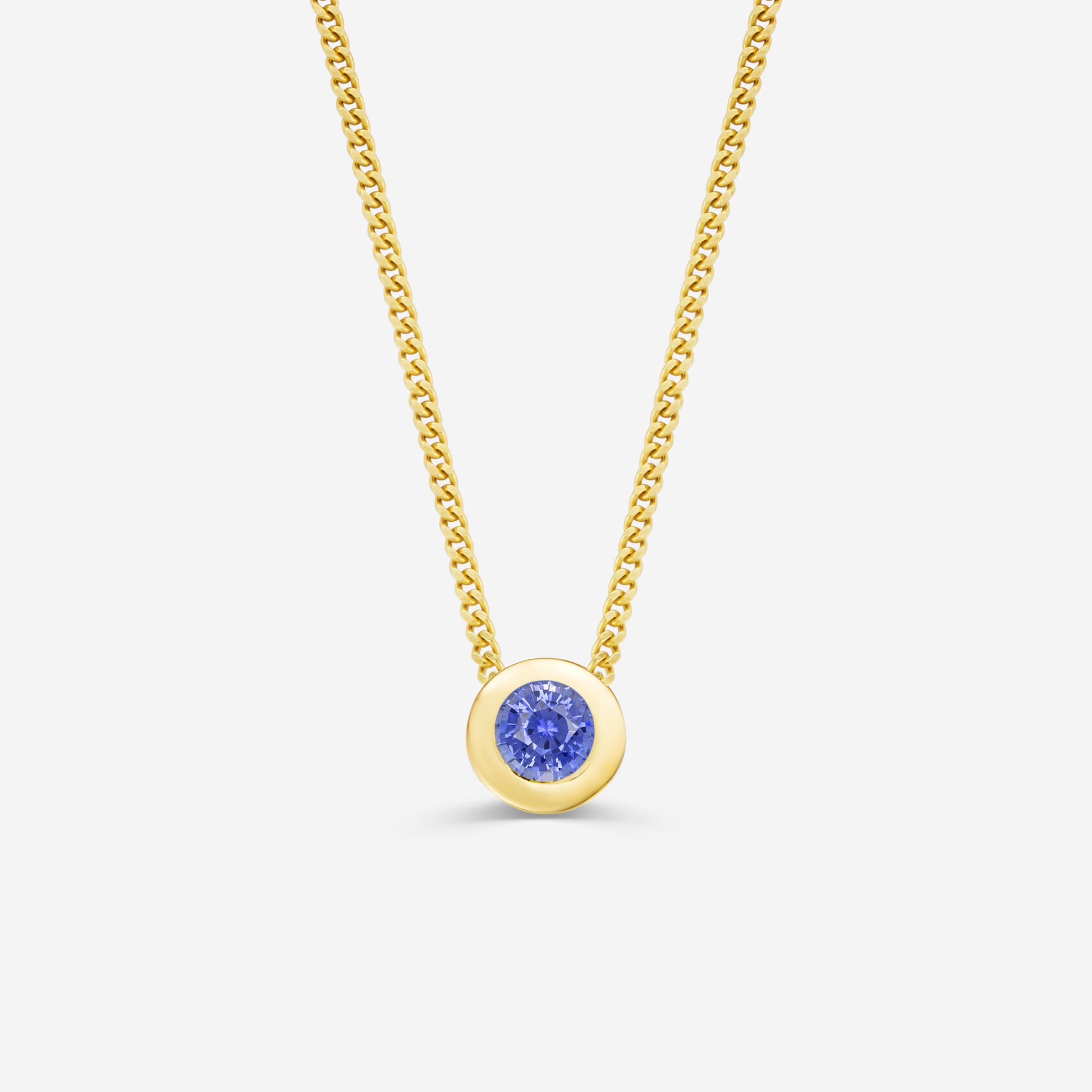 9ct yellow gold necklace with a round sapphire pendant on an off white background