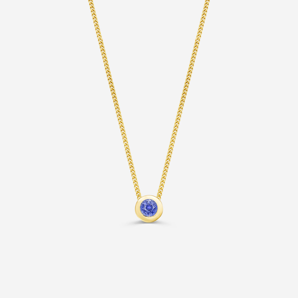 9ct yellow gold necklace with a round sapphire pendant on an off white background