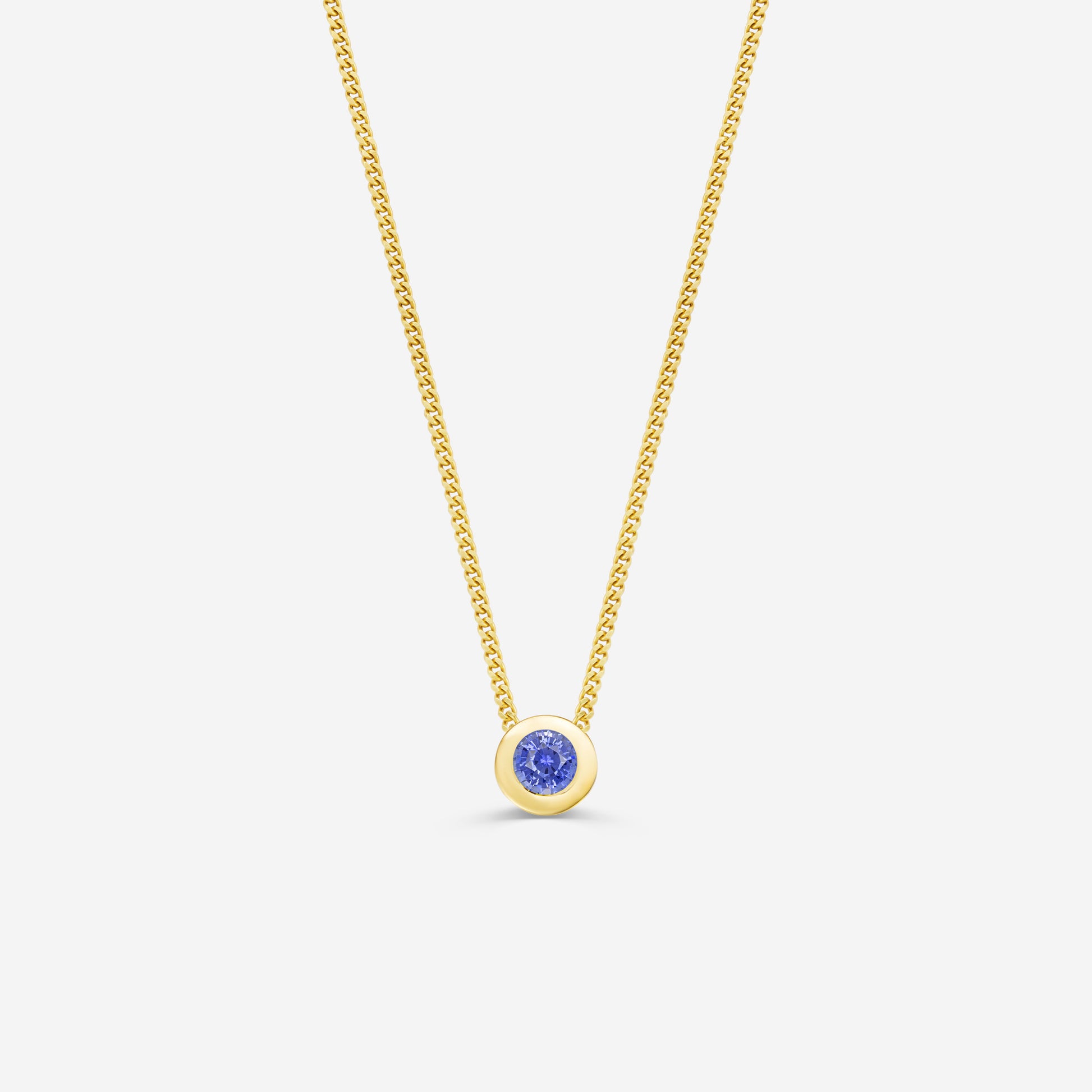 9ct yellow gold necklace with a round sapphire pendant on an off white background