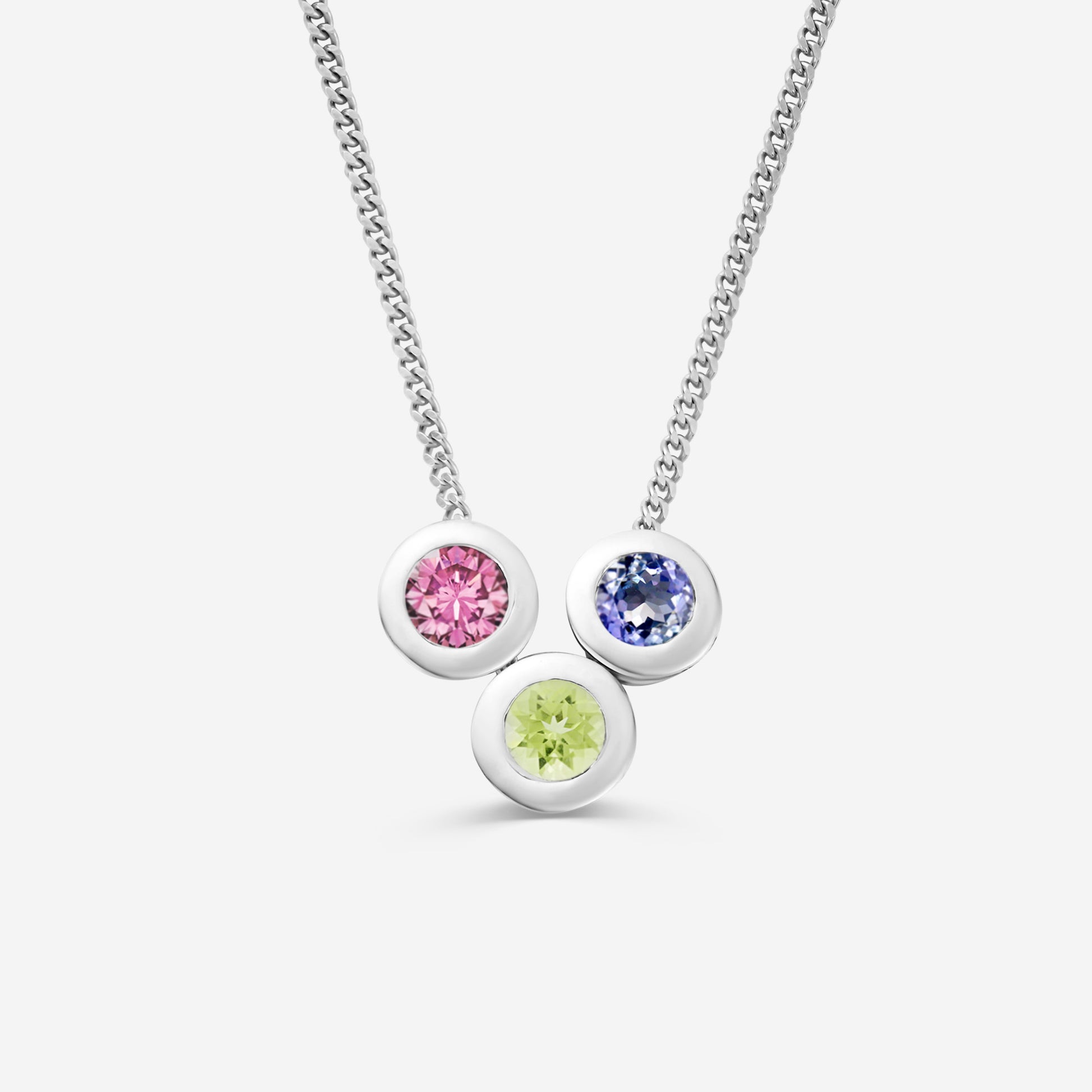 9ct white gold necklace with three round gemstone pendants on an off white background