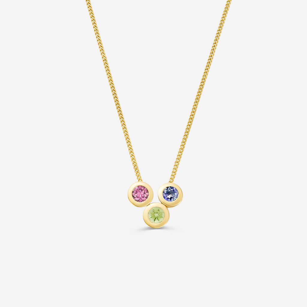 9ct yellow gold necklace with three round gemstone pendants on an off white background