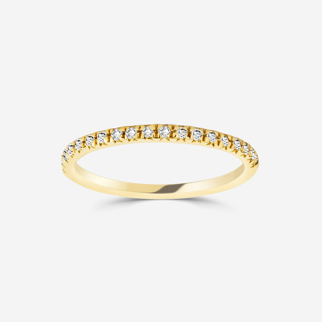 14ct yellow gold eternity ring with diamonds on an off white background