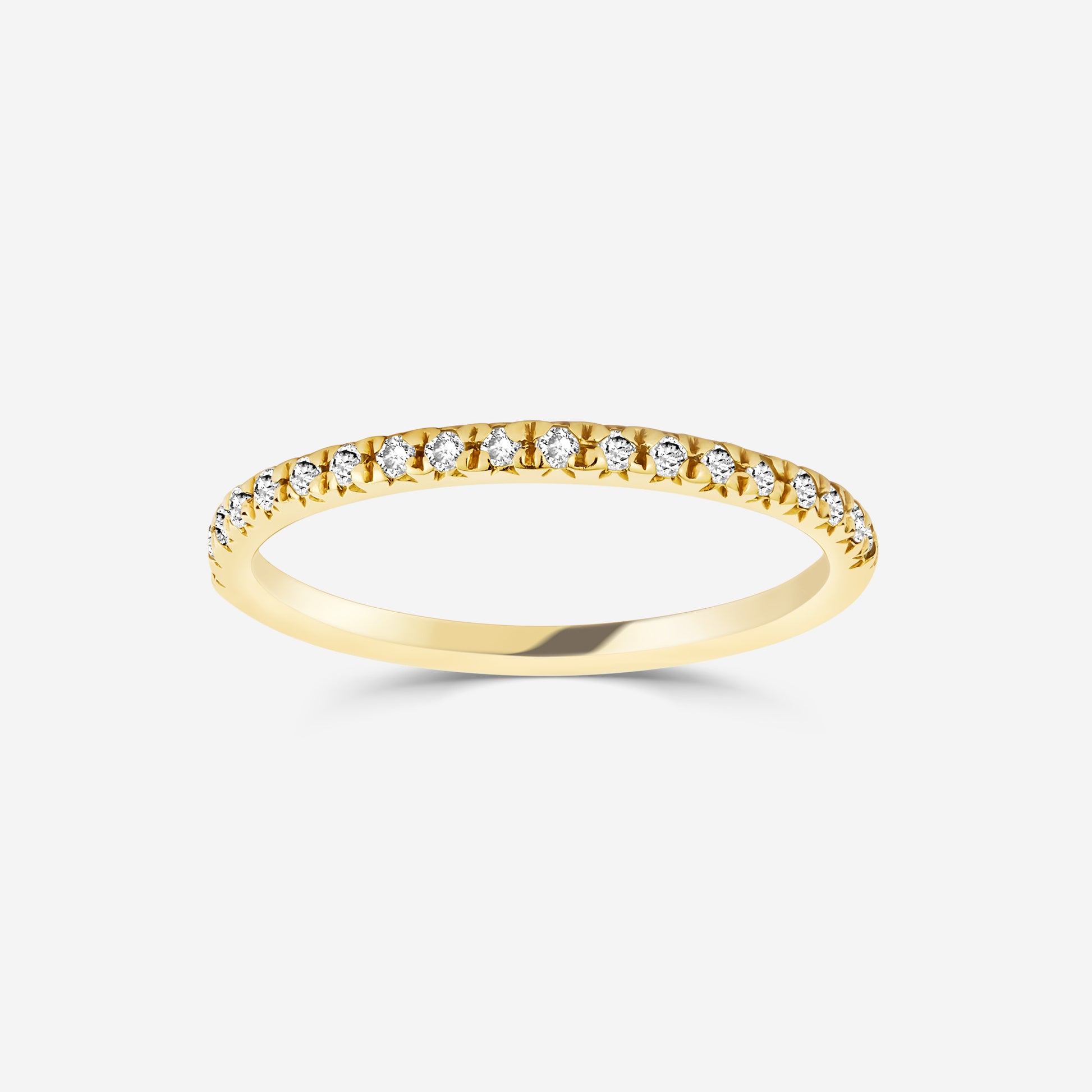14ct yellow gold eternity ring with diamonds on an off white background