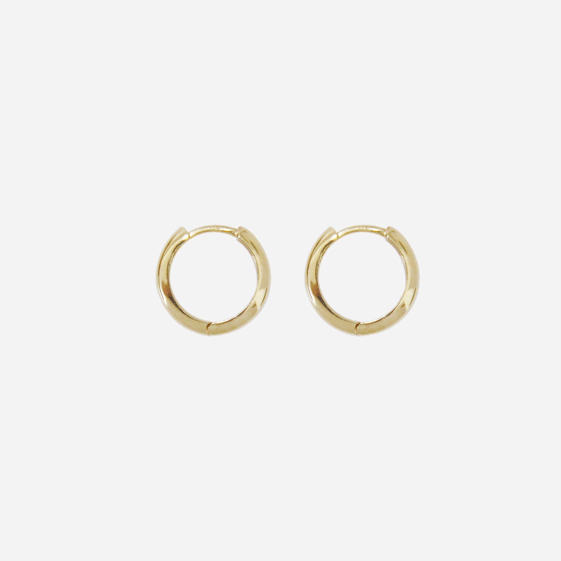 Pair of 14ct yellow gold huggy hoop earrings on an off white background