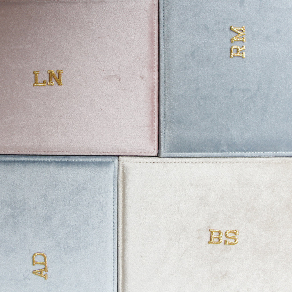 The top of velvet jewellery boxes showing personalised gold embroidered initials.