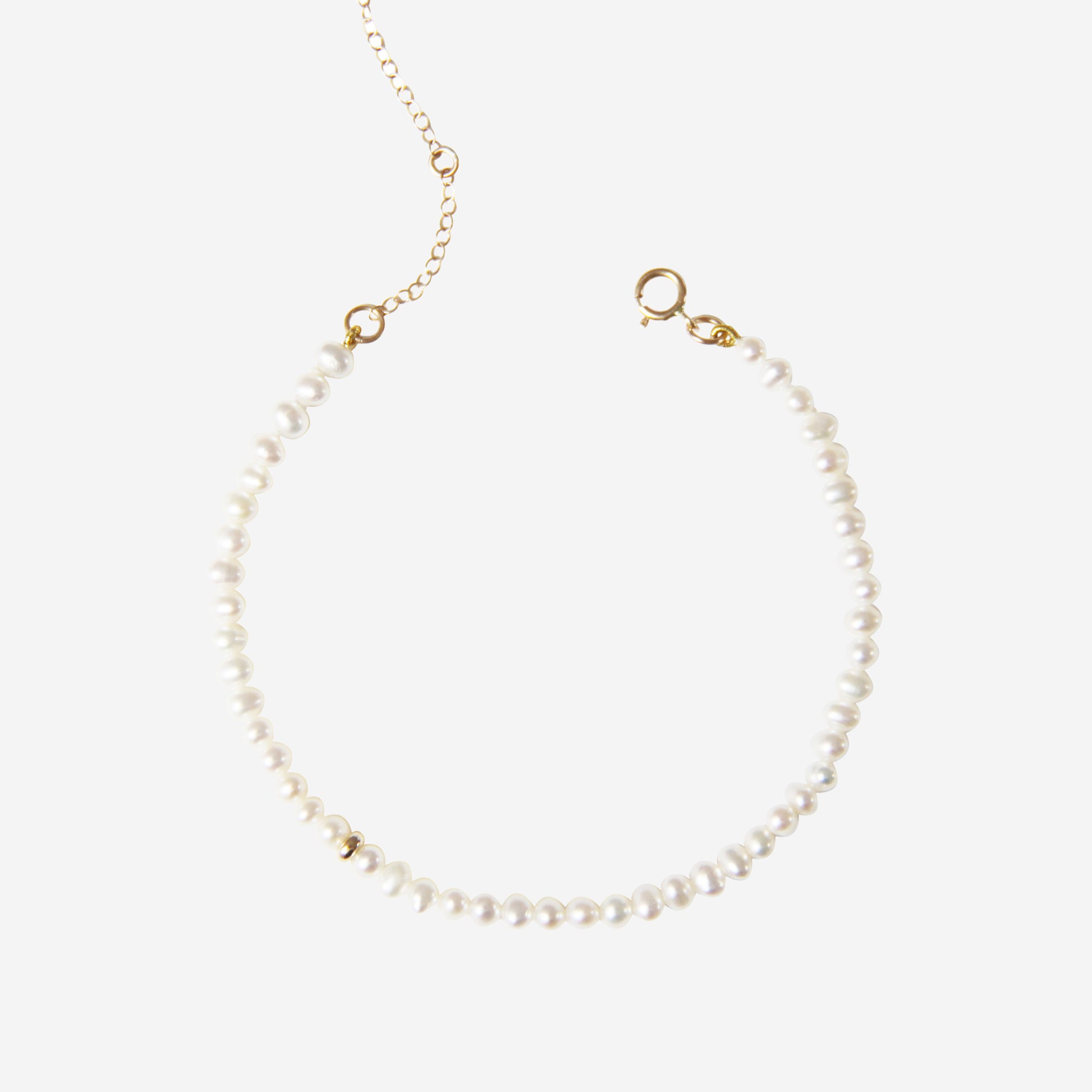 Freshwater pearl bracelet with a14ct gold clasp  gold on an off white background
