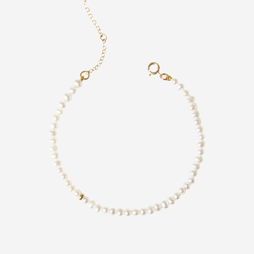 Freshwater pearl bracelet with a14ct gold clasp  gold on an off white background