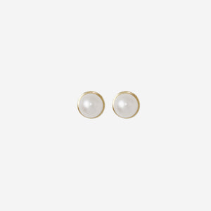 Pair of pearl stud earrings with 14ct gold posts on an off white background
