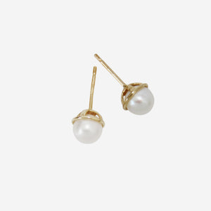 Pair of pearl stud earrings with 14ct gold posts on an off white background
