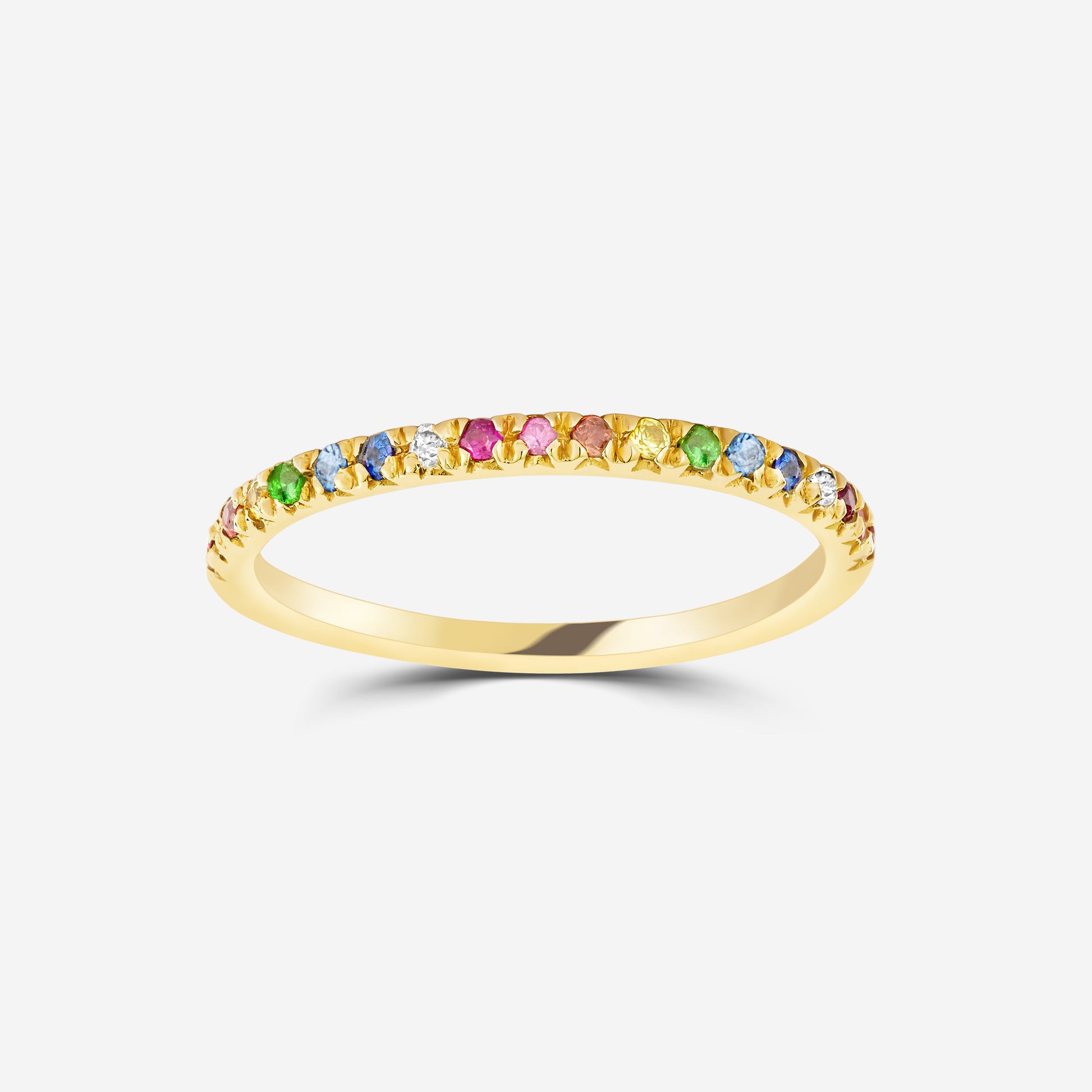 14ct yellow gold eternity ring set with a rainbow of gemstones on an off white background