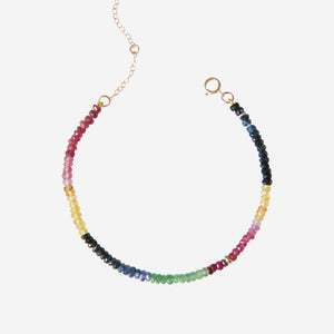 Rainbow beaded bracelet with multicolored beads on an off white background