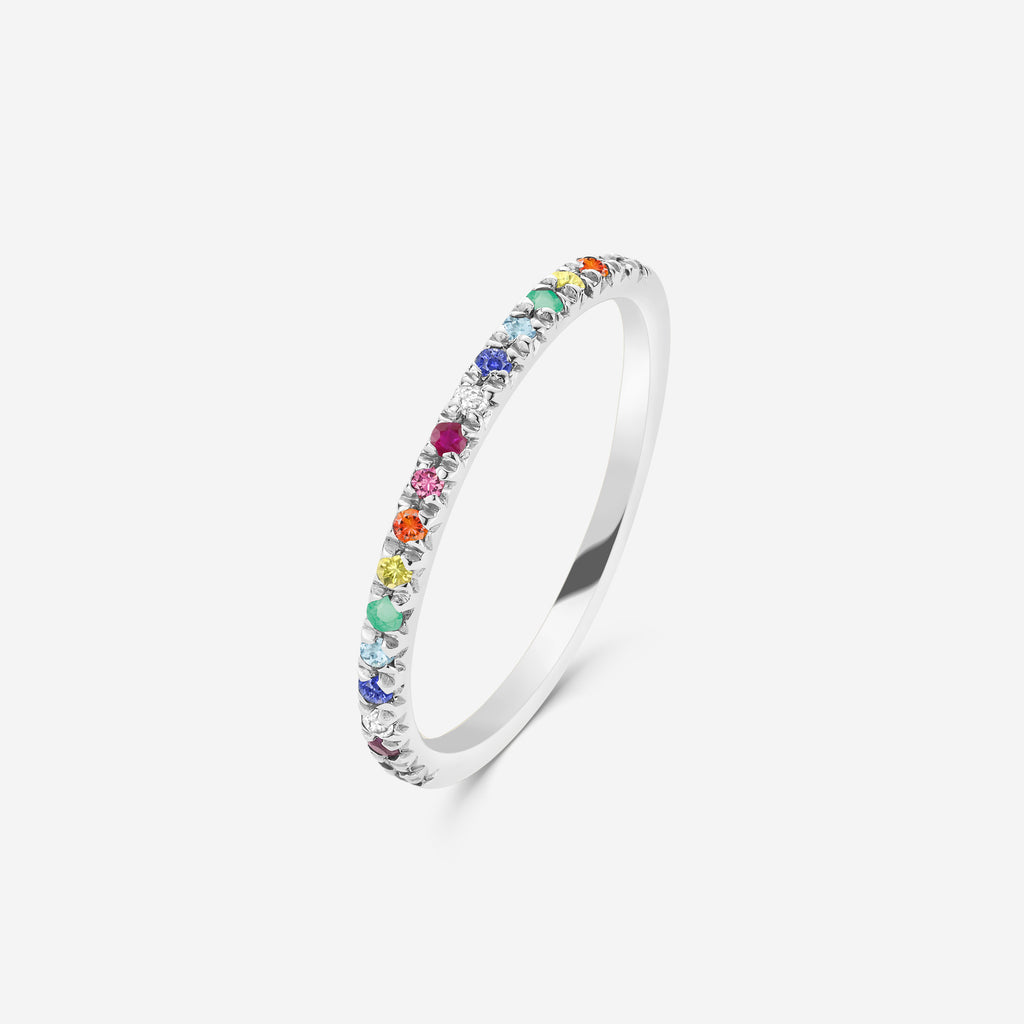 Silver  half eternity ring set with a rainbow of gemstones on an off white background