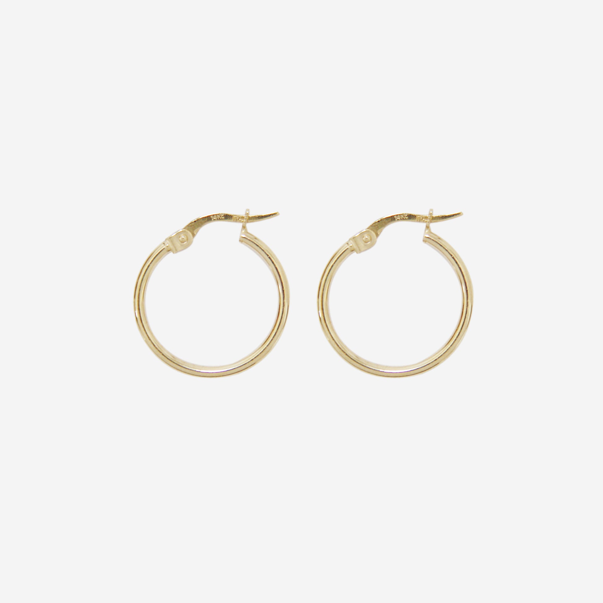 Pair of 14ct yellow gold small hoop earrings on an off white background