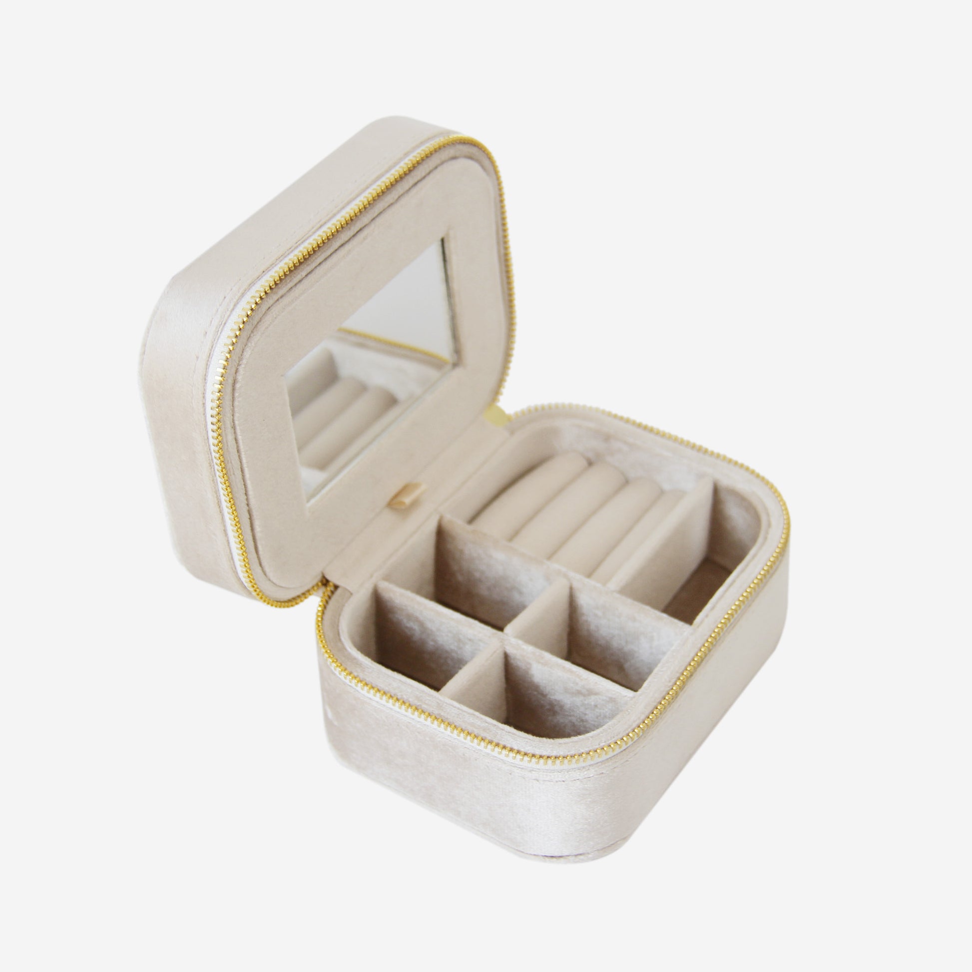 Champagne velvet travel jewelry box with compartments and mirror on an off white background