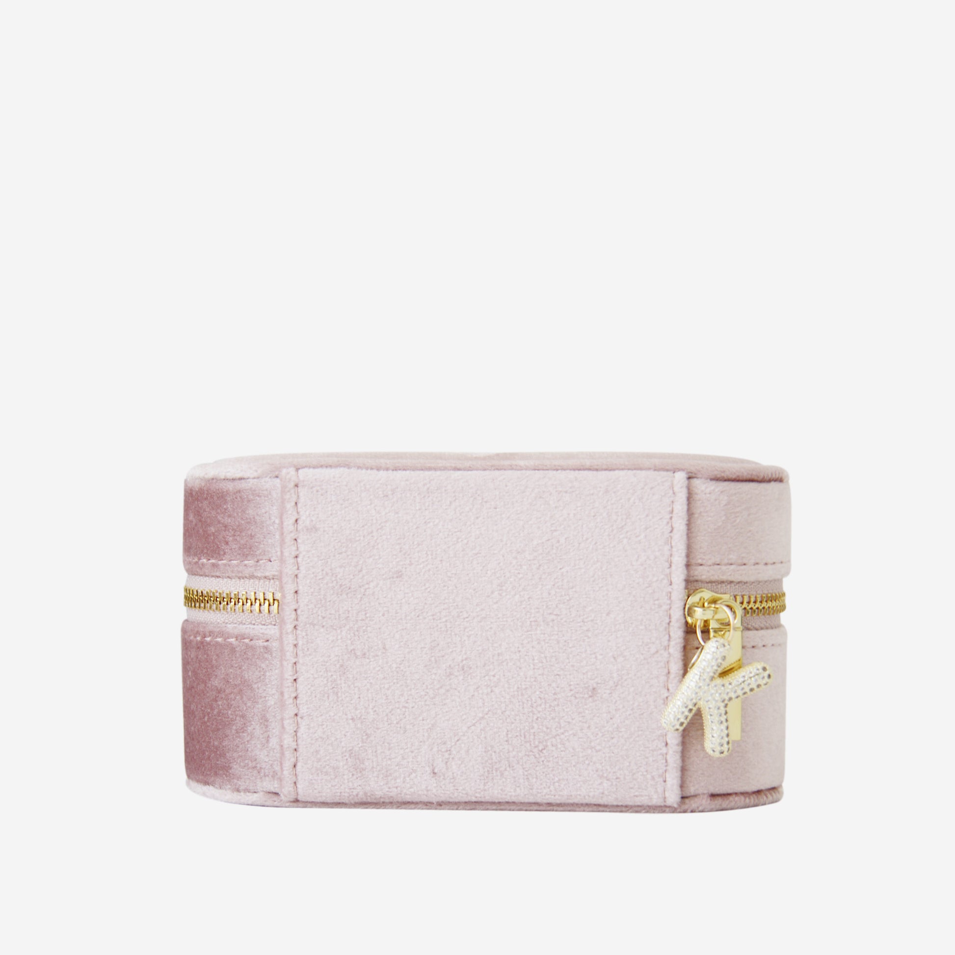 Pink velvet jewelry box with gold zipper and gold and crystal letter 'K' charm on a white background